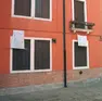 Una casa Ater sfitta e un cartello di protesta