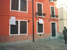 Una casa Ater sfitta e un cartello di protesta