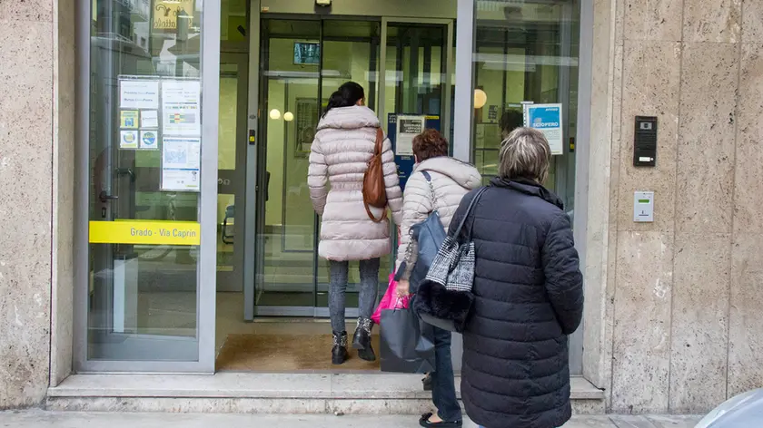 Persone in coda allo sportello bancomat