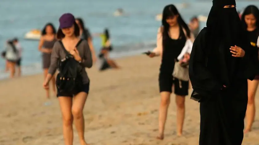 21/02/2016 Penang, Malaysia - Donne musulmane indossano un burqa integrale sulla spiaggia di Penang. Il sindaco di Cannes, nel sud della Francia ha vietato i costumi da bagno conosciuti come burkini