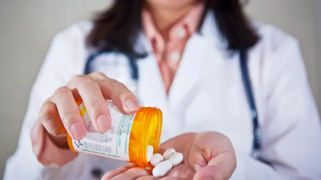 Doctor Holding Bottle of Pills --- Image by © Radius Images/Corbis