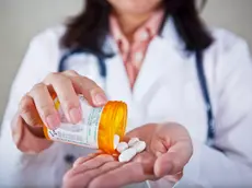 Doctor Holding Bottle of Pills --- Image by © Radius Images/Corbis