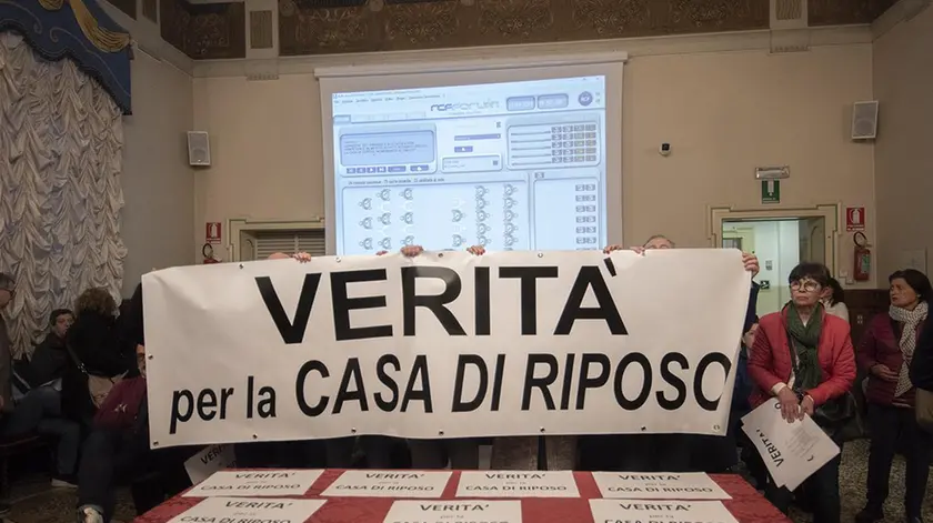 Lo striscione esposto dai familiari degli anziani all’inizio del consiglio comunale di mercoledì sera (foto Vianello)