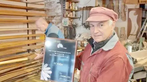 Saverio Pastor, presidente di El Felze, nel suo laboratorio da rèmer con la targa del premio Jiapich 2021