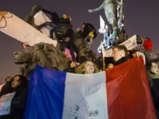 epa04555939 People gather on the monument on Place de la Nation as millions of people march against terrorism in Paris, France, 11 January 2015. Hundreds of thousands of people and more than 40 world leaders were expected for the march honouring the 17 victims killed in three days of terror earlier in the week, which started when gunmen invaded French satirical magazine Charlie Hebdo, continued with the shooting of a policewoman and ended with the siege of a Jewish supermarket EPA/IAN LANGSDON