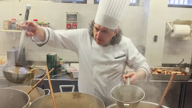 Lo chef Edoardo Raspelli e il suo team cucina la cena per i senza tetto alla mensa Ca' Letizia di Mestre