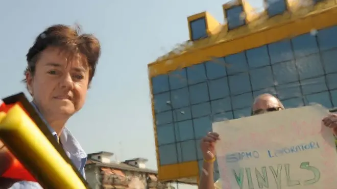 L'operaia Nicoletta Zago come lavavetri ad un incrocio di Mestre, mentre un suo compagno di lavoro mostra agli automobilisti un cartello di protesta, stamattina, 14 luglio 2011. La singolare protesta degli operai della Vinyls di Marghera dopo il fallimento delle trattative per il futuro dell'azienda chimica e il conseguente blocco degli stipendi. Hanno lavato i vetri delle auto, stamani, ad un incrocio, davanti alla sede di Mestre della Provincia di Venezia, i lavoratori della Vinyls di Marghera. E' stata per gli operai una diversa forma di protesta per rimettereal centro dell' attenzione la situazione occupazionale dello stabilimento veneziano. ANSA/ANDREA MEROLA