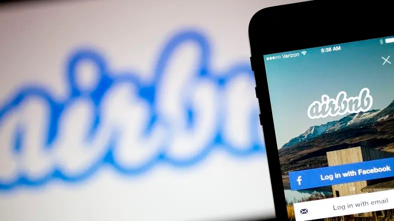 The Airbnb Inc. application and logo are displayed on an Apple Inc. iPhone and iPad in this arranged photograph in Washington, D.C., U.S., on Friday, March 21, 2014. Airbnb Inc. is raising money from investors including TPG Capital in a financing round that would value the room-sharing service at more than $10 billion, said people with knowledge of the deal. Photographer: Andrew Harrer/Bloomberg via Getty Images