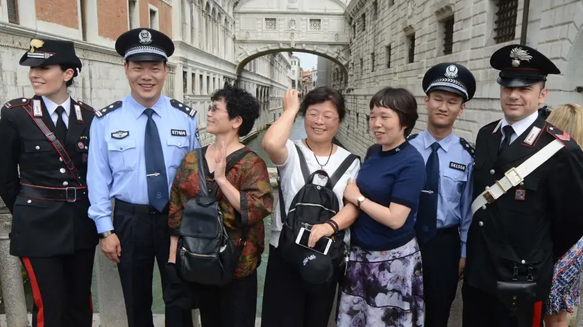 Turisti a caccia di foto con i poliziotti cinesi di pattuglia a Venezia (foto Interpress)