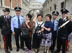 Turisti a caccia di foto con i poliziotti cinesi di pattuglia a Venezia (foto Interpress)