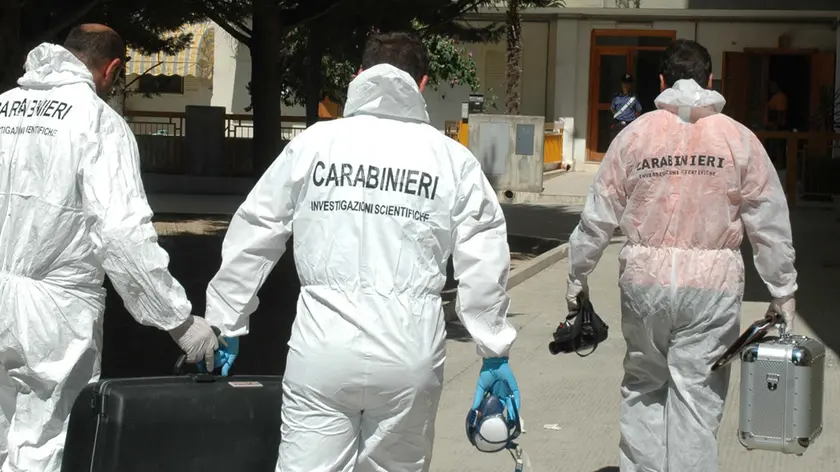 20080802 - CANOSA DI PUGLIA - BARUI - CLJ - UCCIDE MOGLIE E SUOCERA: CADAVERI HANNO CRANI FRACASSATI. Carabinieri della scientifica al loro arrivo nello stabile di via Sardegna, questo pomeriggio a Canosa di Puglia (Bari). Hanno i crani fracassati le due donne, madre e figlia, uccise oggi a Canosa di Puglia, nel barese. Attorno ai cadaveri c'e' una pozza di sangue. Lo si e' appreso da fonti investigative che definiscono ''un mattatoio'' il soggiorno dell'appartamento in cui e' stato compiuto il duplice omicidio. A quanto si e' saputo, a dare l'allarme ai carabinieri e al 118 e' stato il papa' di Lucia Di Muro e marito di Maria Grazia Prisciandaro, le due vittime. L'uomo, infatti, attendeva in auto che la moglie scendesse dall'abitazione della figlia. Infastidito dalla lunga attesa, ha deciso di raggiungere l'appartamento: all'interno ha visto i corpi delle due donne riversi sul pavimento. ANSA/LUCA TURI/DRN
