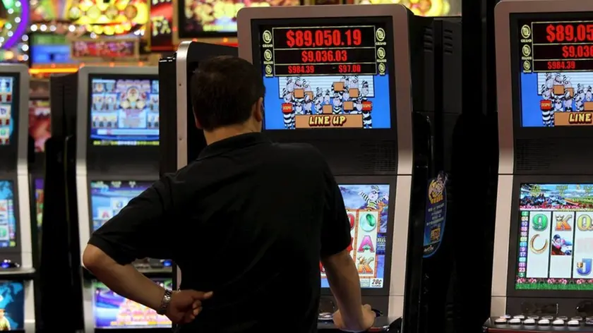 Un uomo gioca con una slot machine in una foto d'archivio. ANSA / YM YIK .