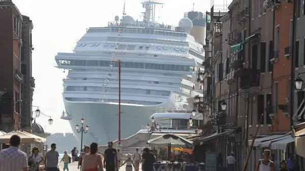 La prua di una grande nave da crociera torreggia all'ingresso di via Garibaldi, nel sestiere di Castello, a nord del centro storico di Venezia, 8 luglio 2011. Così appare ai passanti mentre la meganave è impegnata a curvare verso il Lido, in direzione della bocca di porto di San Nicolò ed il mare aperto. Italia Nostra ha denunciato la pericolosità per Venezia di questo genere di traffico marittimo. .ANSA/ANDREA MEROLA