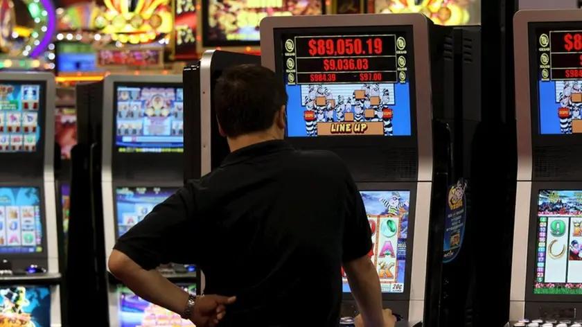 Un uomo gioca con una slot machine in una foto d'archivio. ANSA / YM YIK .