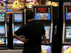 Un uomo gioca con una slot machine in una foto d'archivio. ANSA / YM YIK .