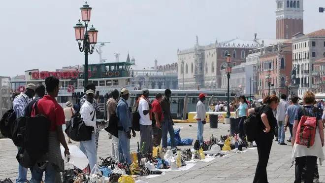 Una foto d'archivio di venditori ambulanti abusivi lungo riva degli Schiavoni a Venezia. ANSA / ANDREA MEROLA