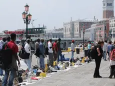 Una foto d'archivio di venditori ambulanti abusivi lungo riva degli Schiavoni a Venezia. ANSA / ANDREA MEROLA