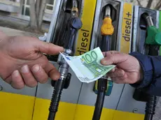 Un benzinaio alla pompa di benzina, riceve un biglietto da 100 euro per il pagamento del carburante da un cliente, 12 marzo 2012 a Pisa. ANSA/FRANCO SILVI