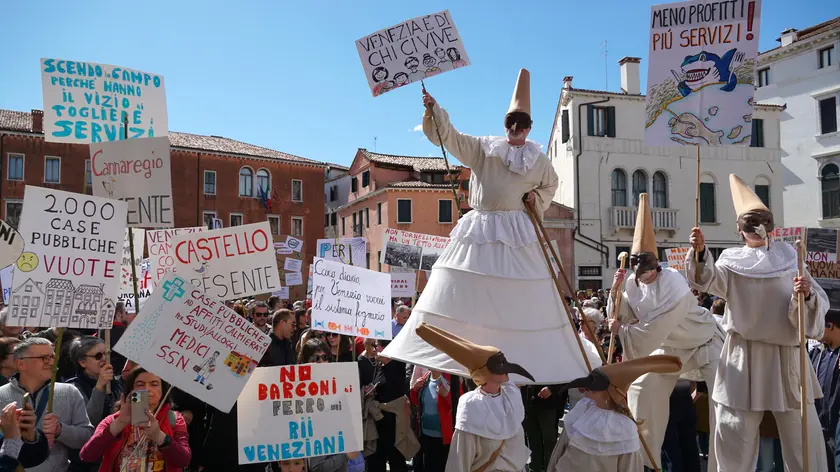 Figuranti travestiti da Pulcinella reggono cartelli a sostegno della salvaguardia di Venezia, tra i manifestanti di trenta associazioni civiche che hanno organizzato un sit-in in campo Sant’Angelo in occasione del cinquantesimo anniversario della Legge Speciale per Venezia, 16 aprile 2023. ANSA/ANDREA MEROLA