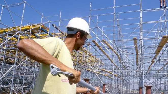 LAVORI EDILI, CANTIERE OPERAIO CON CASCHETTO