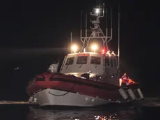 Il barcone carico di migranti arriva alle 5.30 nel porto di Lampedusa, oggi 10 luglio 2011. Il barcone con il motore in avaria e un principio d'incendio a bordo e' stato soccorso in nottata dalla Guardia Costiera a largo di Lampedusa. L'equipaggio della motovedetta Cp 301 e' riuscito a domare l'incendio e a far ripartire il motore per evitare il difficile trasbordo dei 299 profughi partiti dalla Libia, tra i quali 13 donne e un bambino, originari di paesi dell'Africa sub sahariana. ANSA/FRANCESCO MALAVOLTA