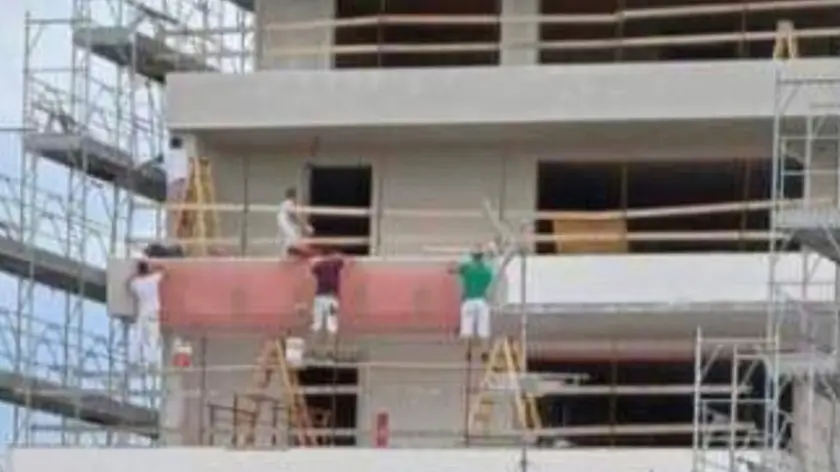 Una delle foto circolate in rete sulla precarietà degli operai al lavoro