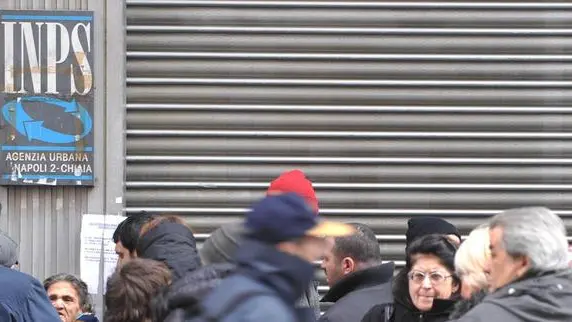 Lavoratori e pensionati in attesa dell'apertura di uno sportello Inps di Napoli, in un'immagine d'archivio. In Italia la pensione media e' pari a circa 1.105 euro. E' quanto emerge dal rapporto su 'trattamenti pensionistici e beneficiari al 31 dicembre 2008', elaborato dall'Istat in collaborazione con l'Inps. L'Istituto di statistica, precisando che il dato potrebbe essere leggermente sottostimato (lievemente ridotto il peso delle indennita' di accompagnamento), aggiunge che le donne rispetto agli uomini ricevono un assegno piu' basso di circa il 30,5%. Infatti, l'importo medio percepito dagli uomini e' di 17.137 euro all'anno, quello delle donne e' invece pari a 11.906 euro. ANSA/CIRO FUSCO/ li
