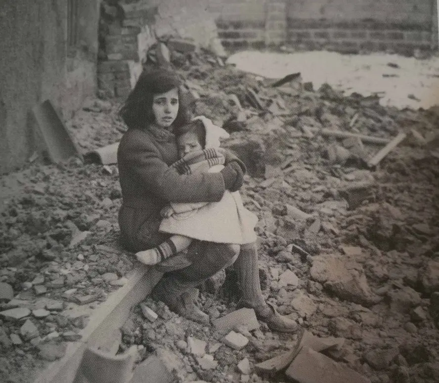 Due bimbe davanti alle macerie della loro casa distrutta. Qualcuno le conosce (foto dal libro di Sergio Barizza)