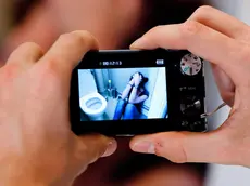 Teenage boy taking picture of a teenage girl at the toilets.