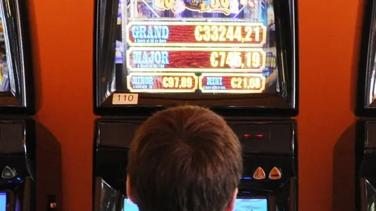 14 Jun 2012, Westerland, Sylt, Germany --- Illustration - A man sits on a slot machine at the casino in Westerland on the island of Sylt, Germany, 14 June 2012. The casino offers events such as the 'Bikers' Night' nad the 'Kitesurf Poker Trophy'. Photo: Angelika Warmuth --- Image by © Angelika Warmuth/dpa/Corbis