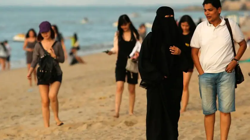 21/02/2016 Penang, Malaysia - Donne musulmane indossano un burqa integrale sulla spiaggia di Penang. Il sindaco di Cannes, nel sud della Francia ha vietato i costumi da bagno conosciuti come burkini