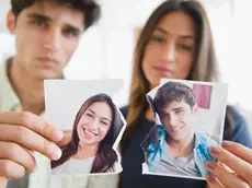 Couple holding torn photograph