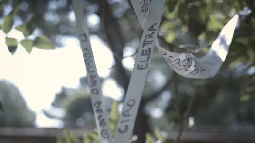 Un frame del documentario: i nastri bianchi al funerale della bambina