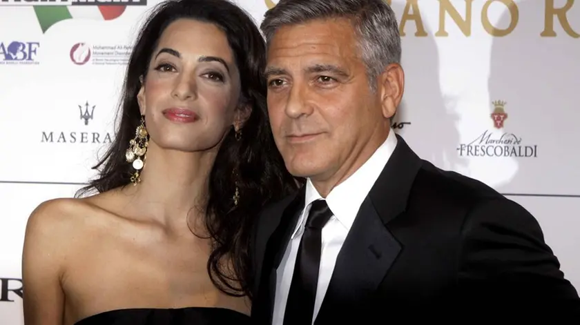 George Clooney and his fiancee Amal Alamuddin pose for photographers as they arrive for the "Celebrity Fight Night" foundation gala dinner, in Florence, Italy, Sunday, Sept. 7, 2014. (AP Photo/Francesco Bellini)