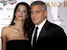 George Clooney and his fiancee Amal Alamuddin pose for photographers as they arrive for the "Celebrity Fight Night" foundation gala dinner, in Florence, Italy, Sunday, Sept. 7, 2014. (AP Photo/Francesco Bellini)