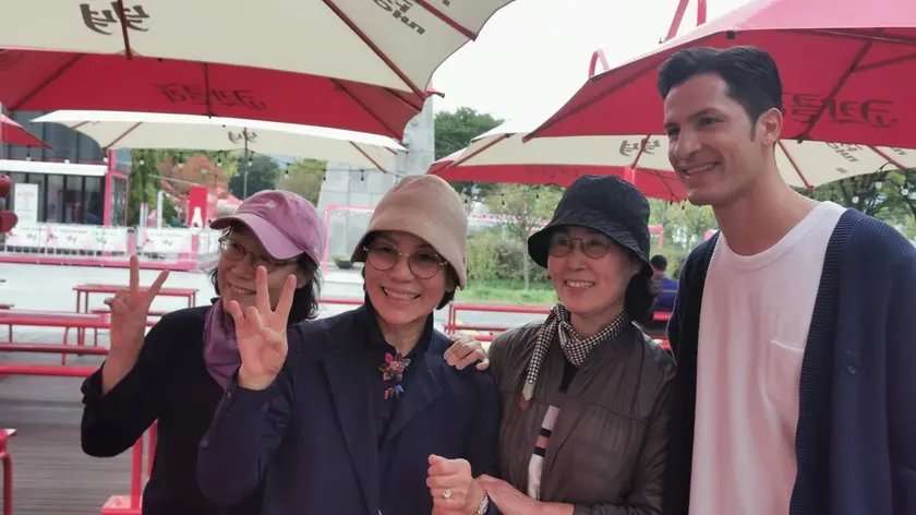 Alberto Mondi posa con un gruppo di fan: appena esce viene riconosciuto, salutato e fermato per una foto ricordo