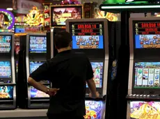 Un uomo gioca con una slot machine in una foto d'archivio. ANSA / YM YIK .