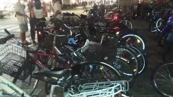 Il piazzale della basilica di San Giacomo pieno di biciclette e scooter