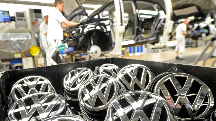 Emblems of VW Golf VII car are pictured in a production line at the plant of German carmaker Volkswagen in Wolfsburg in this February 25, 2013 file photo. Volkswagen said February 27, 2013 it will pay its German workers a 7,200-euro ($9,400) bonus for 2012, a reduction of 4 percent on the previous year's payout despite Europe's biggest car maker having posted a record profit and sales. Picture taken February 25, 2013. REUTERS/Fabian Bimmer/file (GERMANY - Tags: TRANSPORT)