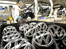 Emblems of VW Golf VII car are pictured in a production line at the plant of German carmaker Volkswagen in Wolfsburg in this February 25, 2013 file photo. Volkswagen said February 27, 2013 it will pay its German workers a 7,200-euro ($9,400) bonus for 2012, a reduction of 4 percent on the previous year's payout despite Europe's biggest car maker having posted a record profit and sales. Picture taken February 25, 2013. REUTERS/Fabian Bimmer/file (GERMANY - Tags: TRANSPORT)