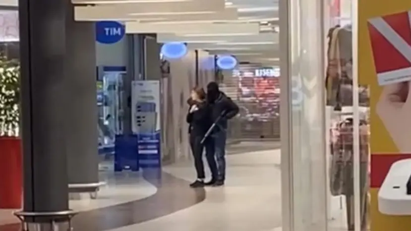 Il bandito che tiene in ostaggio la commessa