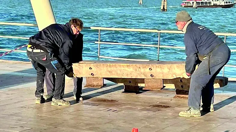 I tecnici di Veritas mentre tolgono la panchina vicino al terminal di Santa Maria Elisabetta
