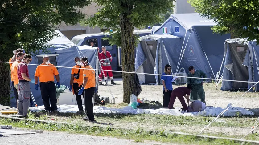 The bodies of some victims lie in the ground for the recognition by the family, in Amatrice on 25 August 2016. ANSA/MASSIMO PERCOSSI