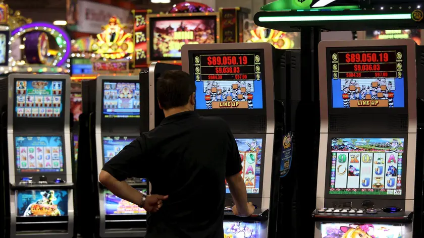 Un uomo gioca con una slot machine in una foto d'archivio. ANSA / YM YIK .