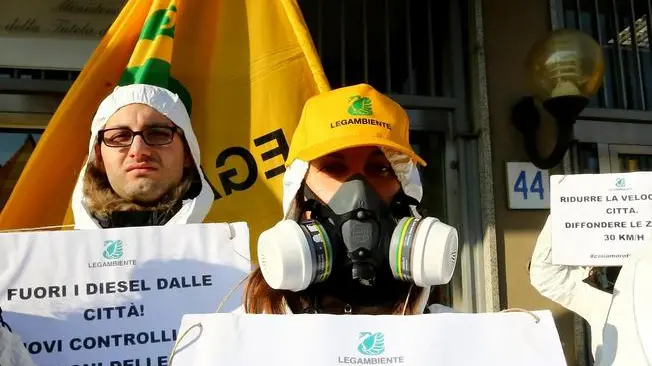 Un momento del flash mob di Legambiente davanti al ministero dell'Ambiente in occasione della riunione sull'emergenza smog, Roma, 30 dicembre 2015. Attivisti in tuta bianca con maschere antigas mostrano cartelli con alcune proposte per ridurre l'inquinamento: dai treni per i pendolari alla ciclabilità urbana,al bando dei diesel in città. ANSA/ FABIO CAMPANA