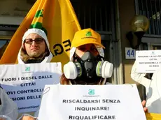 Un momento del flash mob di Legambiente davanti al ministero dell'Ambiente in occasione della riunione sull'emergenza smog, Roma, 30 dicembre 2015. Attivisti in tuta bianca con maschere antigas mostrano cartelli con alcune proposte per ridurre l'inquinamento: dai treni per i pendolari alla ciclabilità urbana,al bando dei diesel in città. ANSA/ FABIO CAMPANA