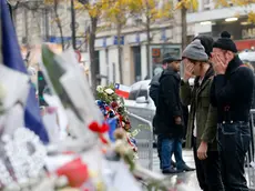 Members of the band Eagles of Death Metal, Jesse Hughes, right, and Julian Dorio pay their respects to 89 victims who died in a Nov. 13 major extremist attack, at the Bataclan concert hall in Paris, France, Tuesday, Dec. 8, 2015. Members of the California rock band Eagles of Death Metal are back at the ravaged Paris theater where they survived a massacre by Islamic extremist suicide bombers. (AP Photo/Jacques Brinon)