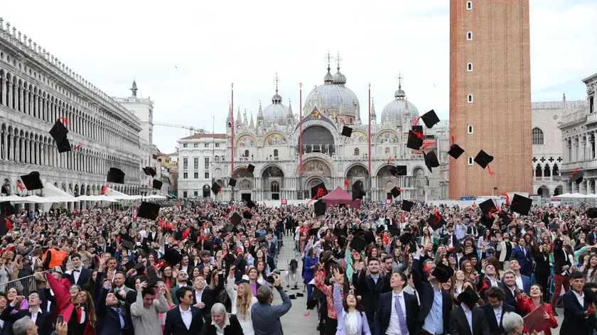 Il momento del tradizionale lancio del tocco, cioè del cappello degli universitari (fotoservizio Marta Buso/Interpress)