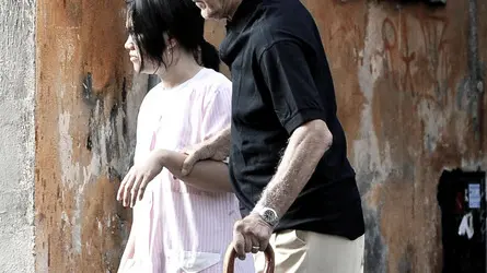 Una badante straniera accompagna un anziano signore per le vie del centro di Roma,in una foto del 2 settembre 2009. I costi dell'assistenza ai disabili pesano sempre di piu' sulle loro famiglie. E in tempo di crisi i parenti studiano strategie di ''arrangiamento organizzato'' che passano anche attraverso il volontariato, prima di rivolgersi al settore privato o alle badanti. E' quanto emerge dal 44mo Rapporto annuale del Censis sulla situazione sociale del Paese, che ha stimato in oltre 56mila euro, il costo di un malato di Alzheimer all'anno. Cifra che scende a 11.250 euro/anno per un paziente con artrite reumatoide e circa 15mila euro per i malati di insufficienza renale cronica in dialisi. ANSA/ GUIDO MONTANI