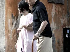 Una badante straniera accompagna un anziano signore per le vie del centro di Roma,in una foto del 2 settembre 2009. I costi dell'assistenza ai disabili pesano sempre di piu' sulle loro famiglie. E in tempo di crisi i parenti studiano strategie di ''arrangiamento organizzato'' che passano anche attraverso il volontariato, prima di rivolgersi al settore privato o alle badanti. E' quanto emerge dal 44mo Rapporto annuale del Censis sulla situazione sociale del Paese, che ha stimato in oltre 56mila euro, il costo di un malato di Alzheimer all'anno. Cifra che scende a 11.250 euro/anno per un paziente con artrite reumatoide e circa 15mila euro per i malati di insufficienza renale cronica in dialisi. ANSA/ GUIDO MONTANI